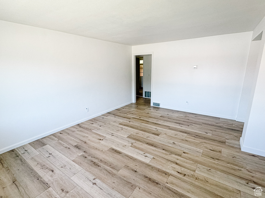Empty room with light wood-style flooring and baseboards