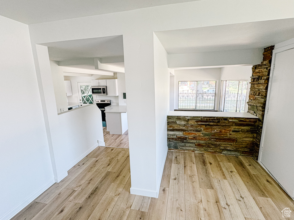 Hall featuring light wood finished floors and baseboards