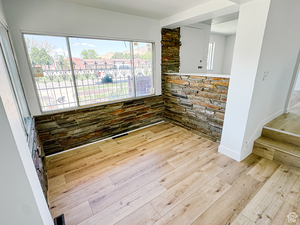 Empty room featuring wood finished floors, healthy amount of natural light, and stairway