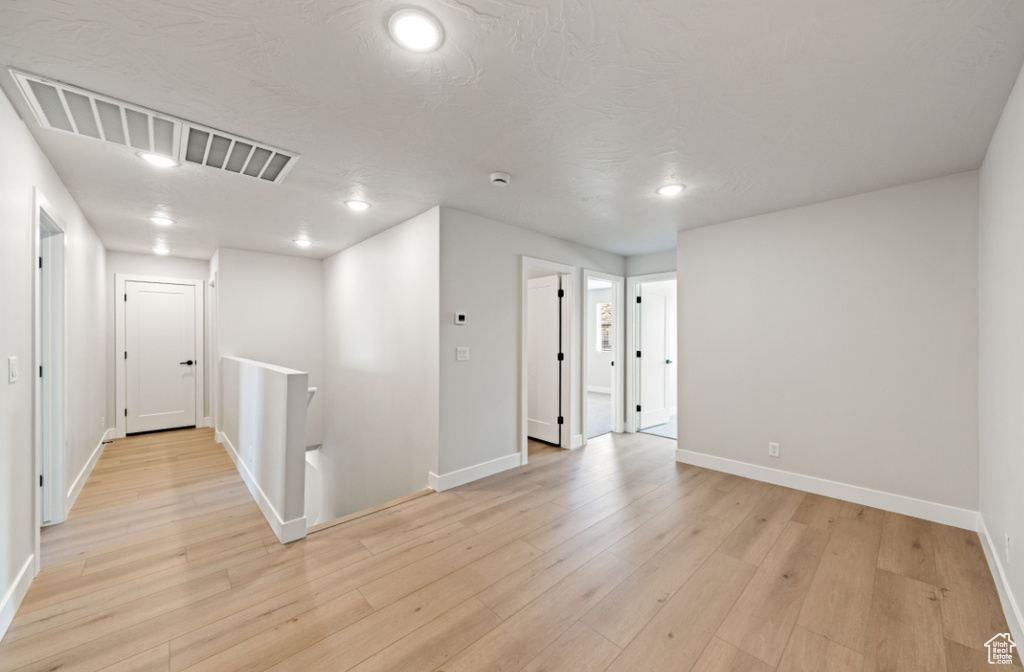 Spare room featuring baseboards, recessed lighting, and light wood-style floors