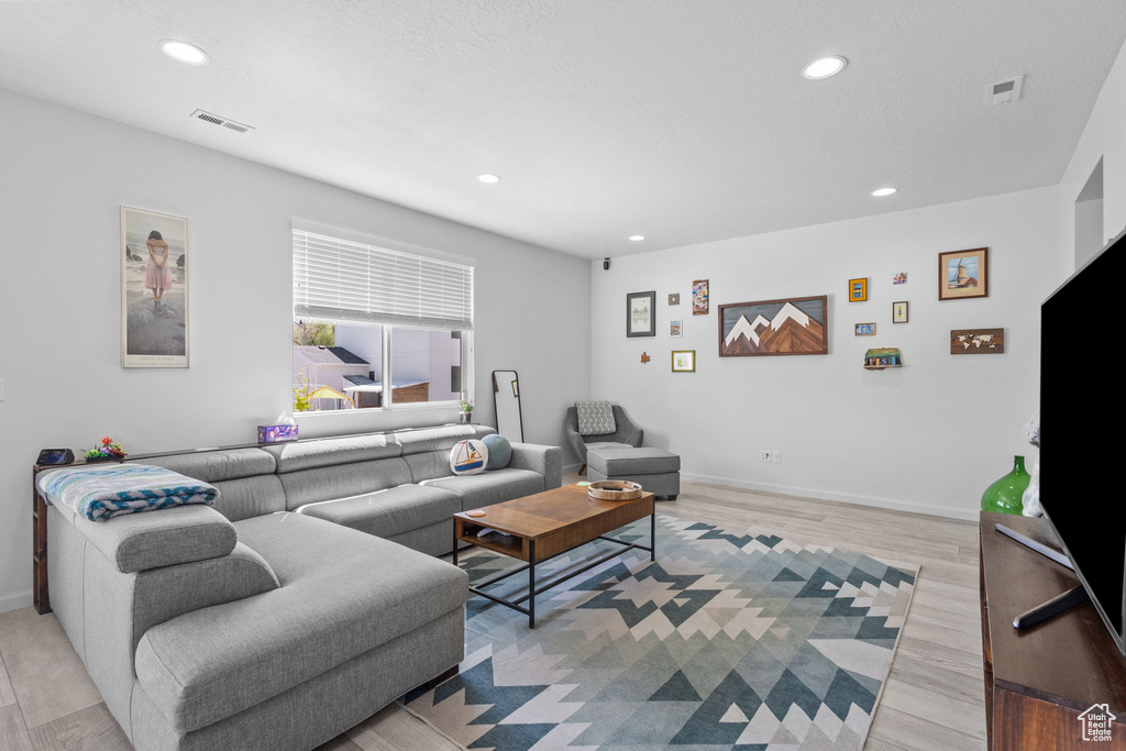 Living area with recessed lighting, light wood-style floors, and baseboards