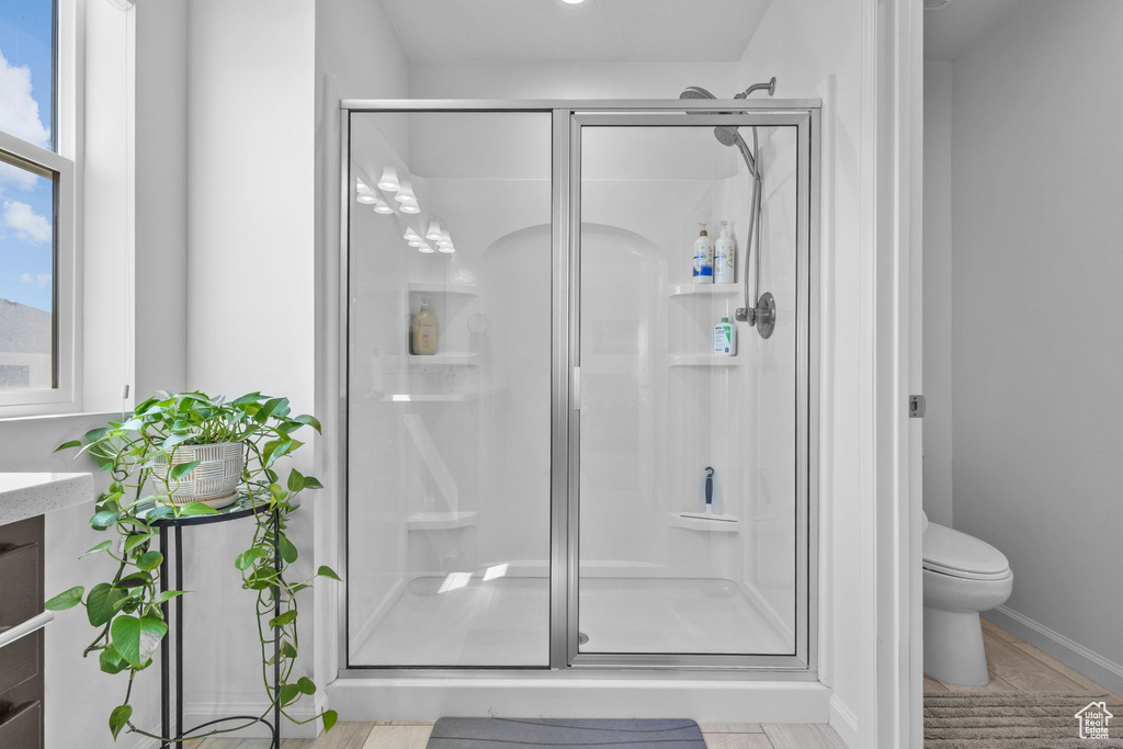 Bathroom with a shower stall, toilet, and vanity