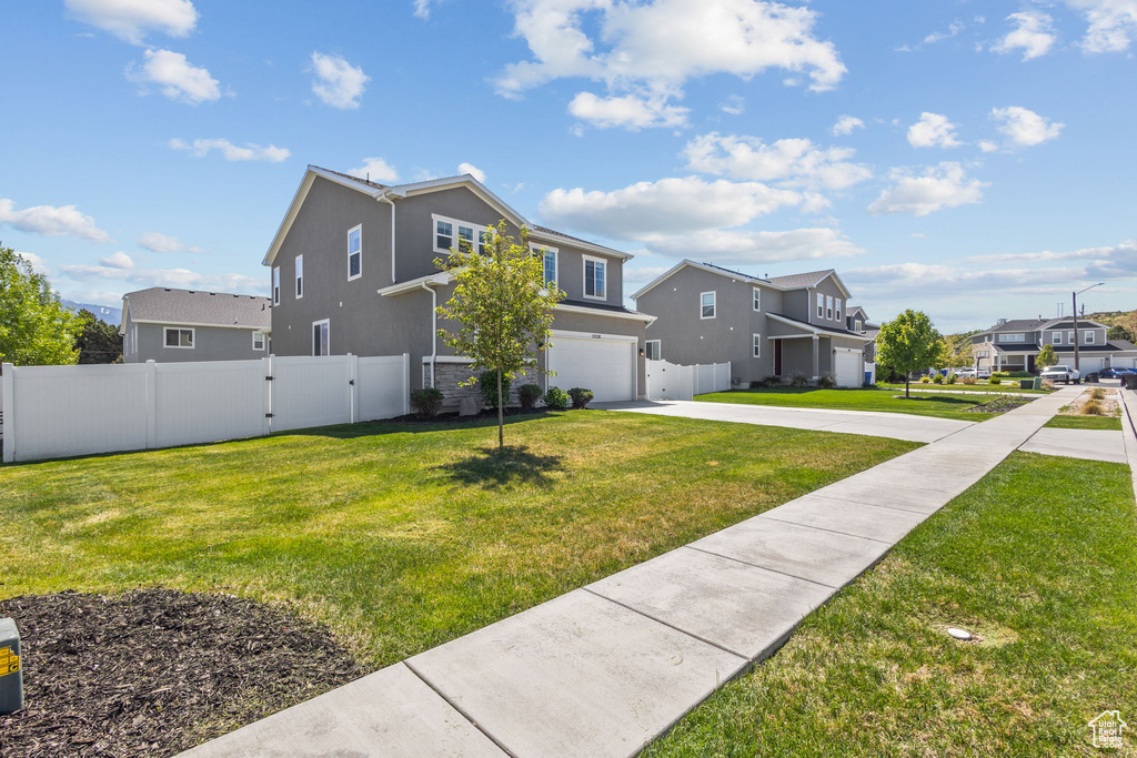 View of home\'s exterior featuring an attached garage, driveway, stucco siding, a residential view, and a gate
