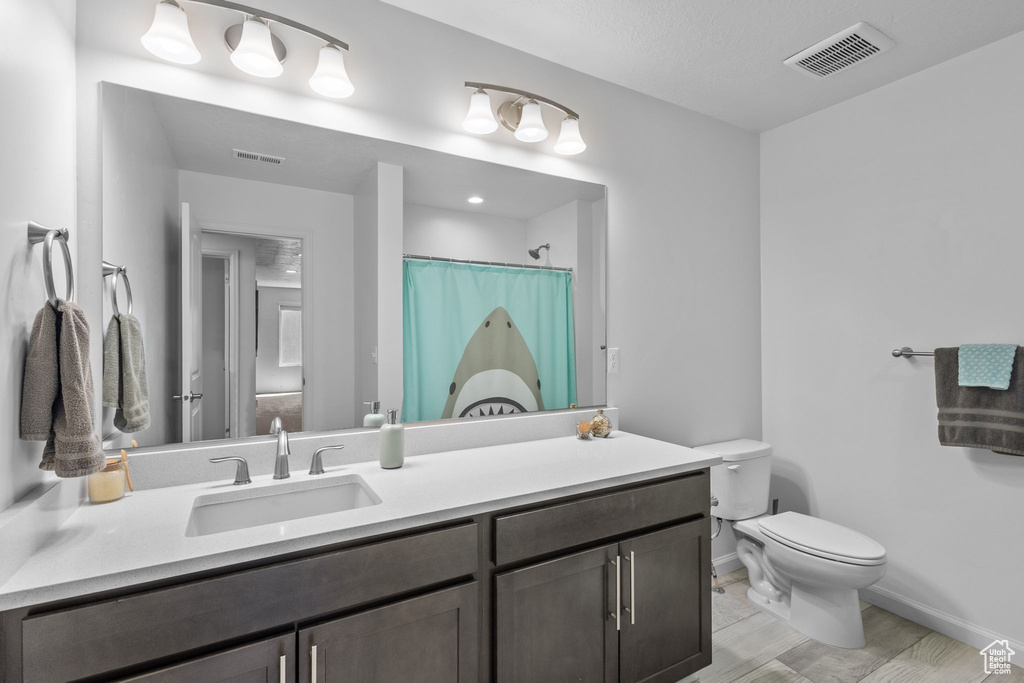 Bathroom with toilet, baseboards, vanity, and a shower with shower curtain