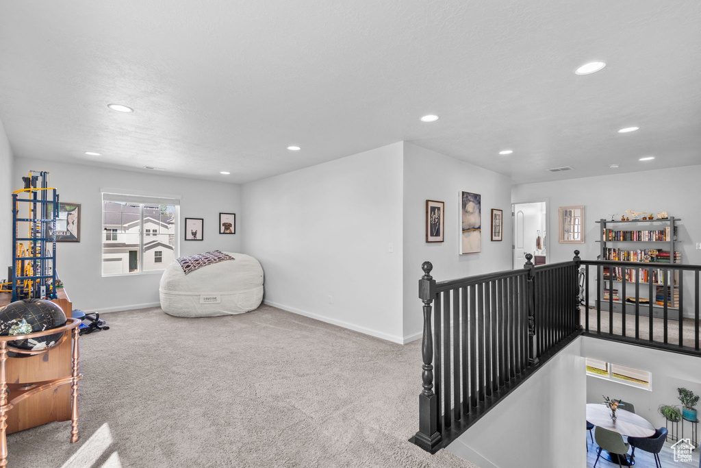 Sitting room with recessed lighting, an upstairs landing, baseboards, and carpet flooring