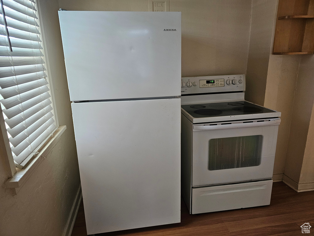 Kitchen featuring white appliances and dark wood finished floors