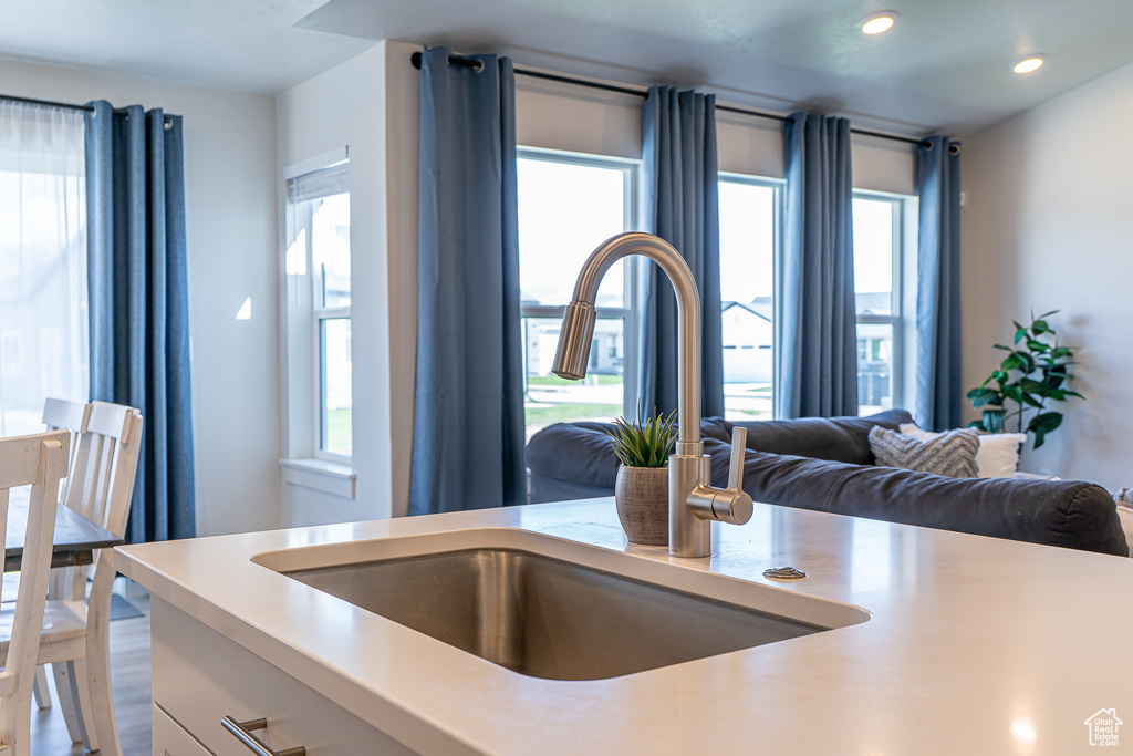 Kitchen featuring a sink, light countertops, recessed lighting, and open floor plan