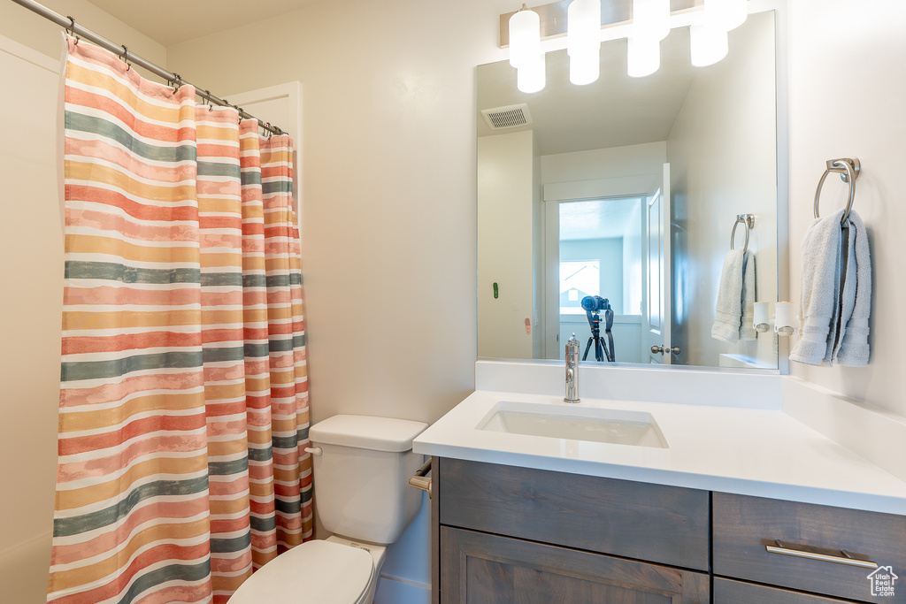 Full bath featuring toilet, vanity, and a shower with shower curtain