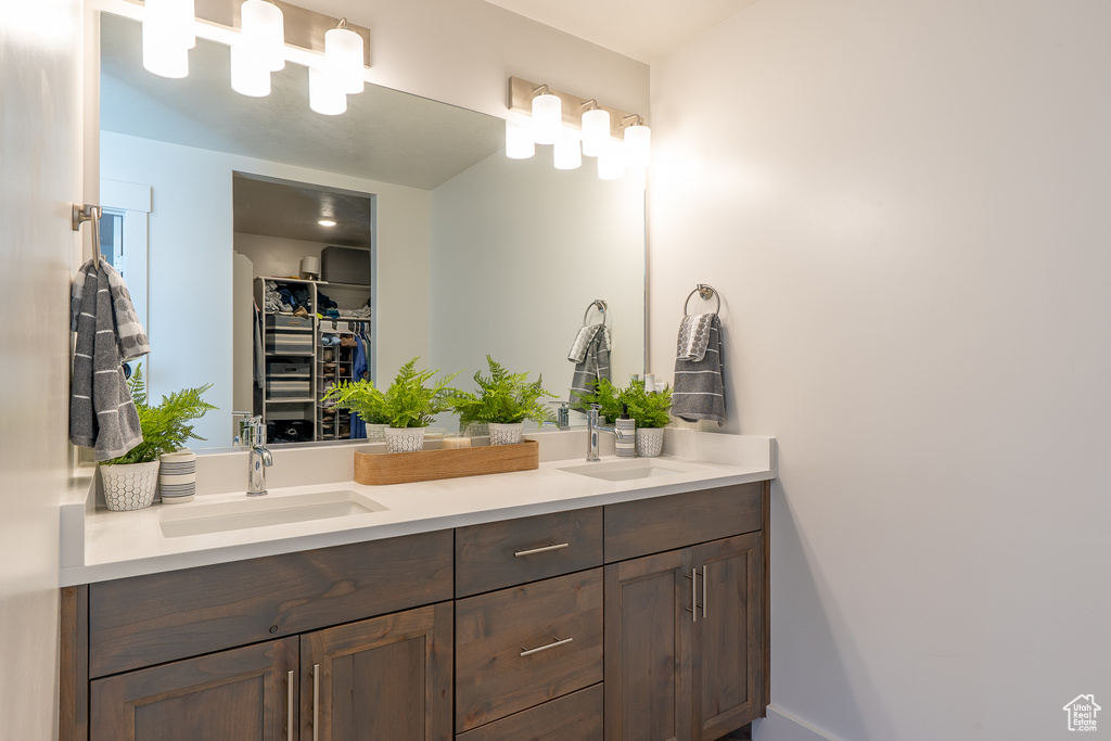 Full bathroom featuring double vanity and a walk in closet