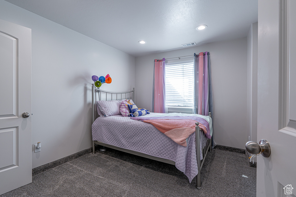 Bedroom with dark carpet, recessed lighting, and baseboards