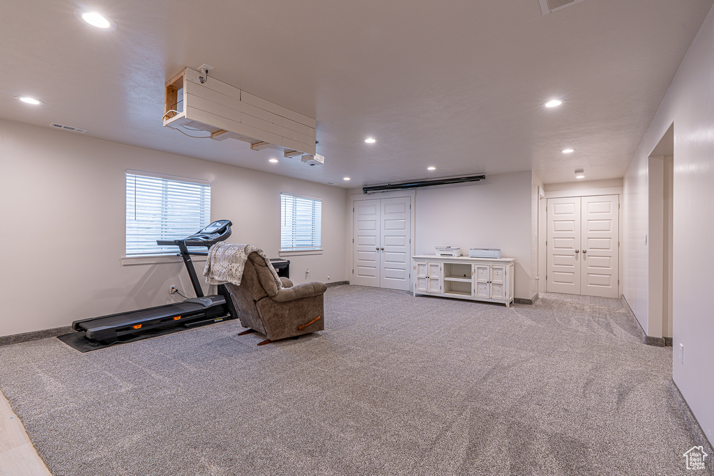 Living area with carpet flooring, recessed lighting, and baseboards
