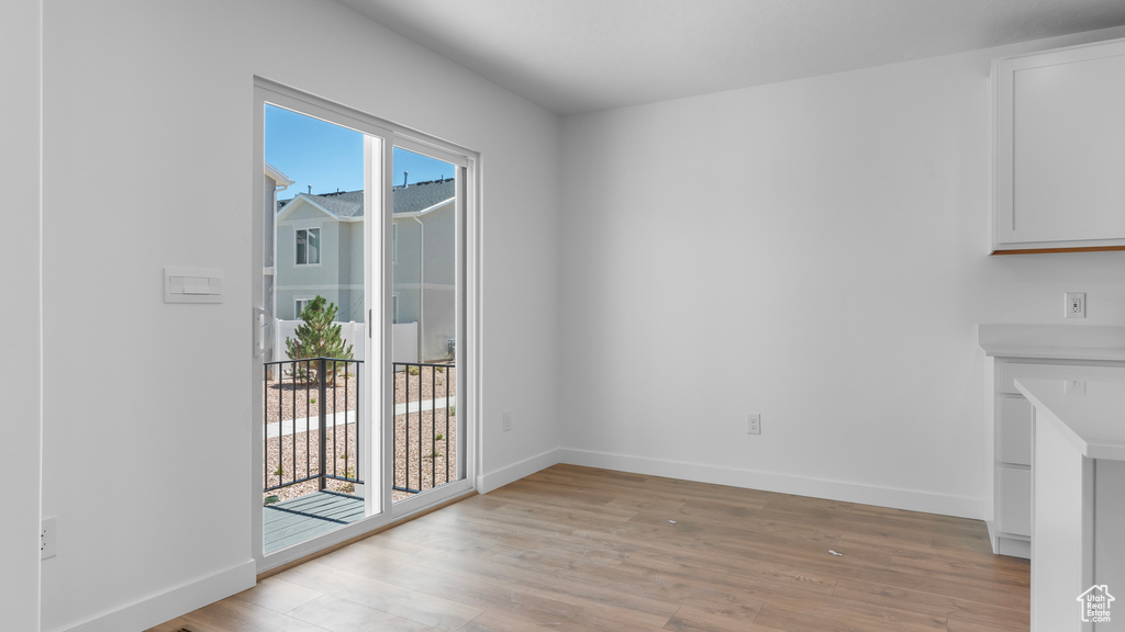 Unfurnished dining area featuring light wood-style floors and baseboards