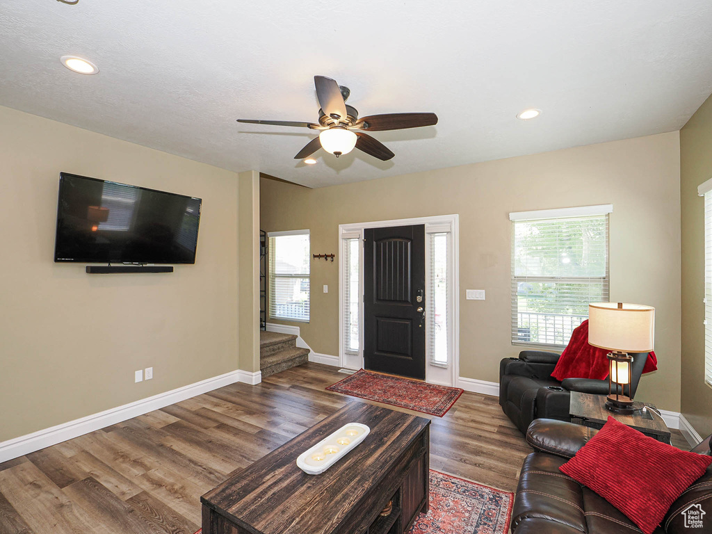 Living area featuring wood finished floors, ceiling fan, baseboards, and recessed lighting