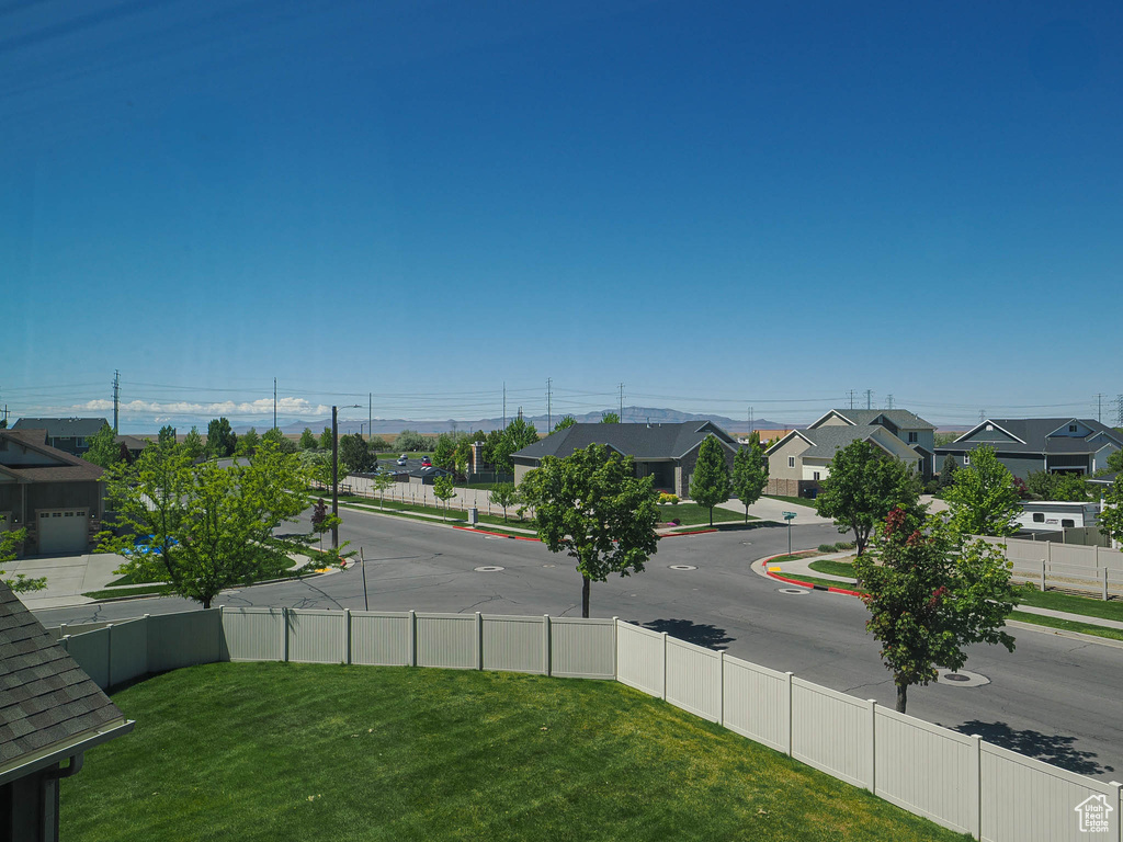 View of asphalt road featuring a residential view, sidewalks, and curbs