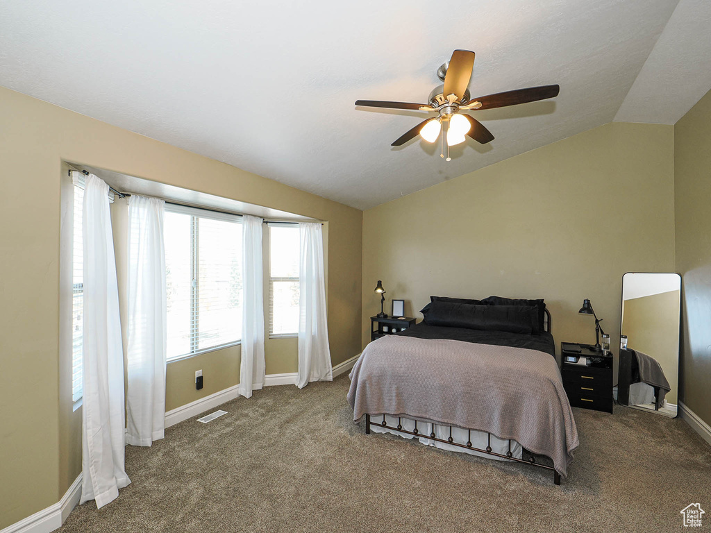 Bedroom featuring lofted ceiling, carpet flooring, baseboards, and ceiling fan