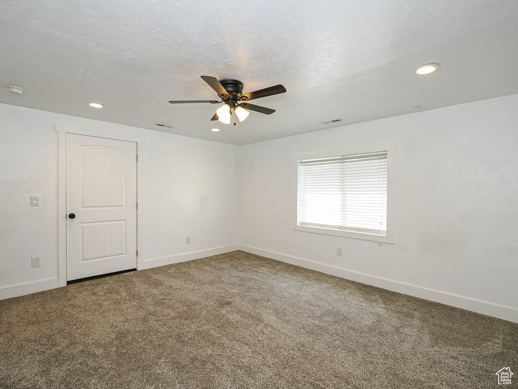 Carpeted empty room with a ceiling fan, baseboards, recessed lighting, and a smoke detector