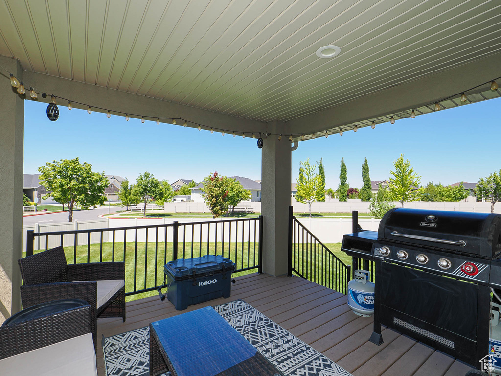 Wooden terrace with a yard, a grill, and a residential view