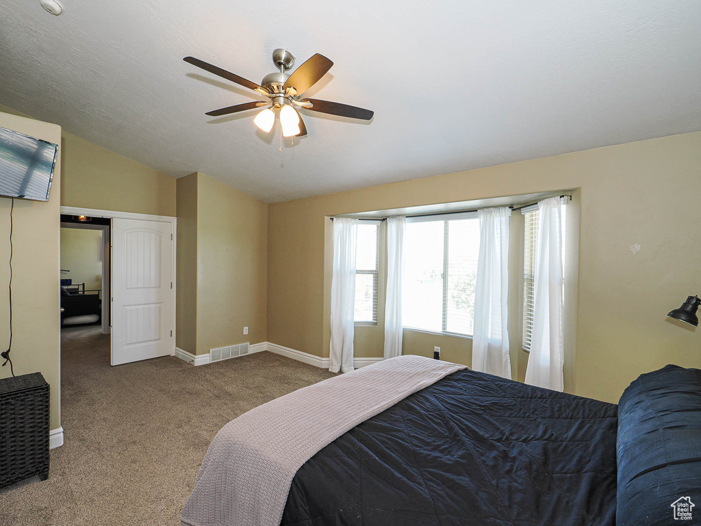 Bedroom with carpet flooring, vaulted ceiling, baseboards, and ceiling fan