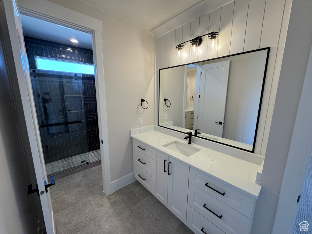 Bathroom with vanity, a stall shower, and baseboards