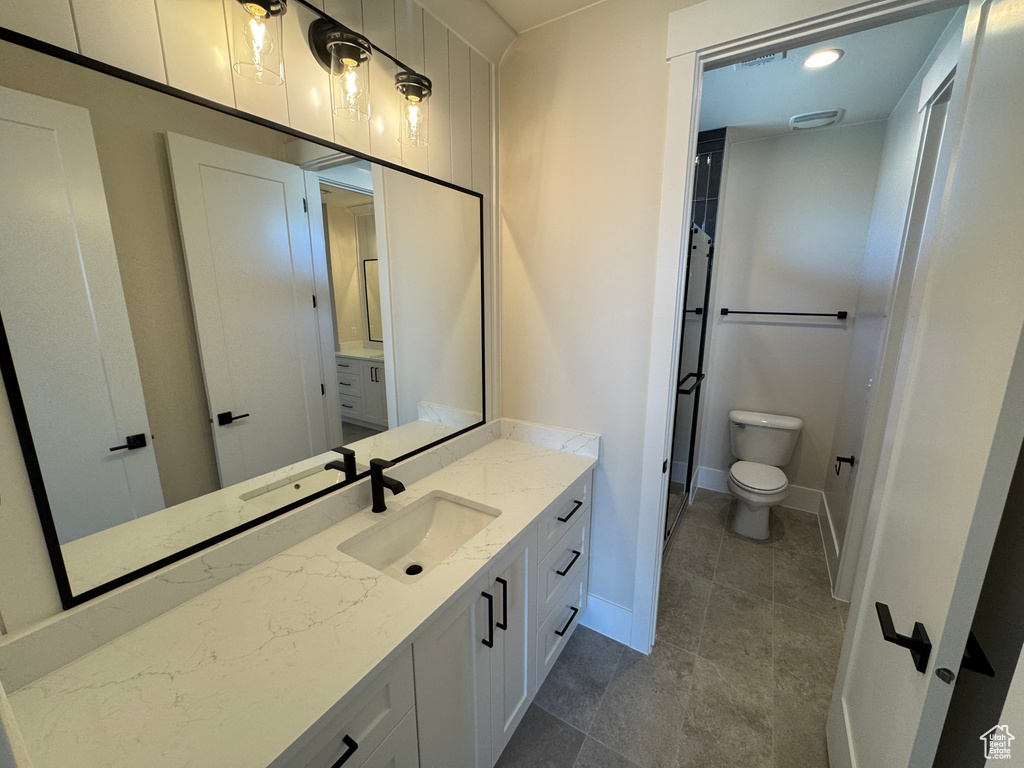Bathroom featuring toilet, vanity, and baseboards
