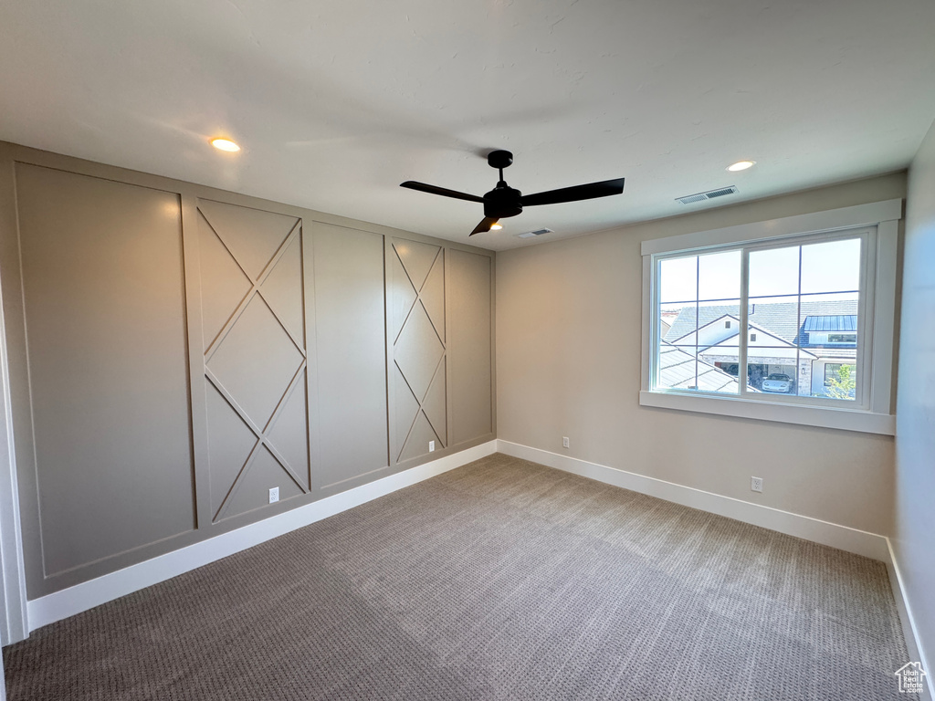 Unfurnished room with baseboards, light carpet, ceiling fan, recessed lighting, and a decorative wall