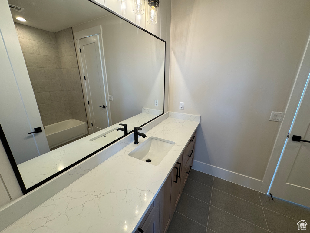 Full bath featuring vanity, tile patterned floors, and baseboards