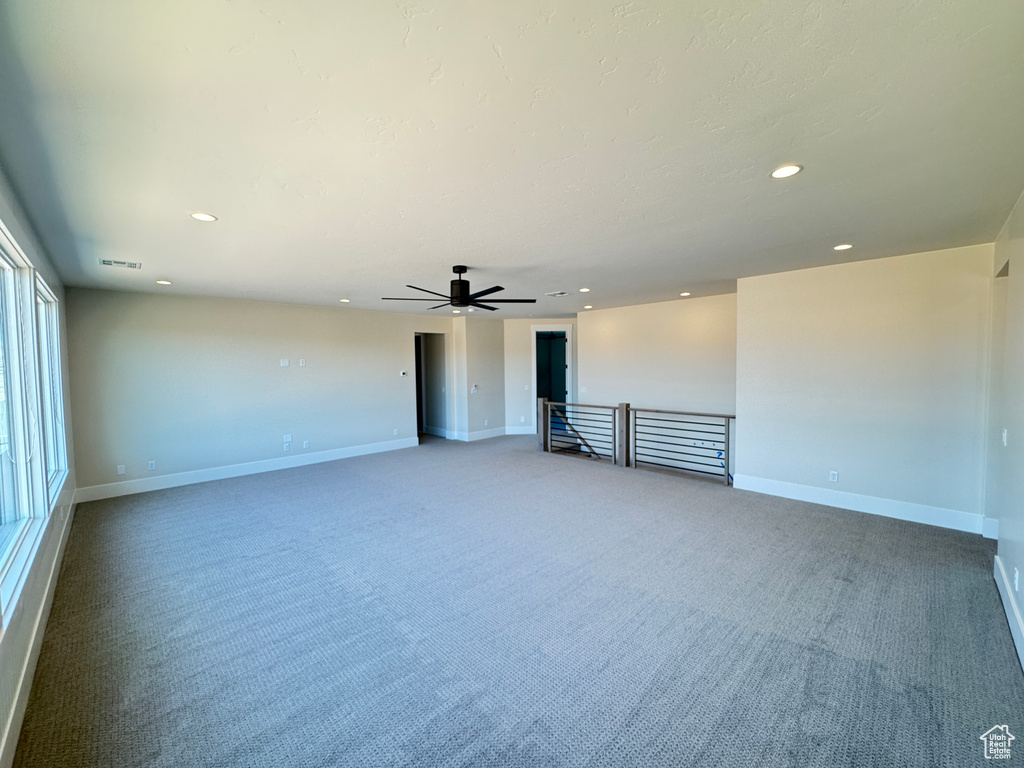Carpeted spare room featuring recessed lighting, ceiling fan, and baseboards