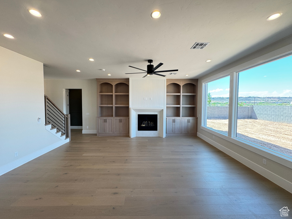 Unfurnished living room with recessed lighting, baseboards, light wood-style floors, stairway, and a ceiling fan