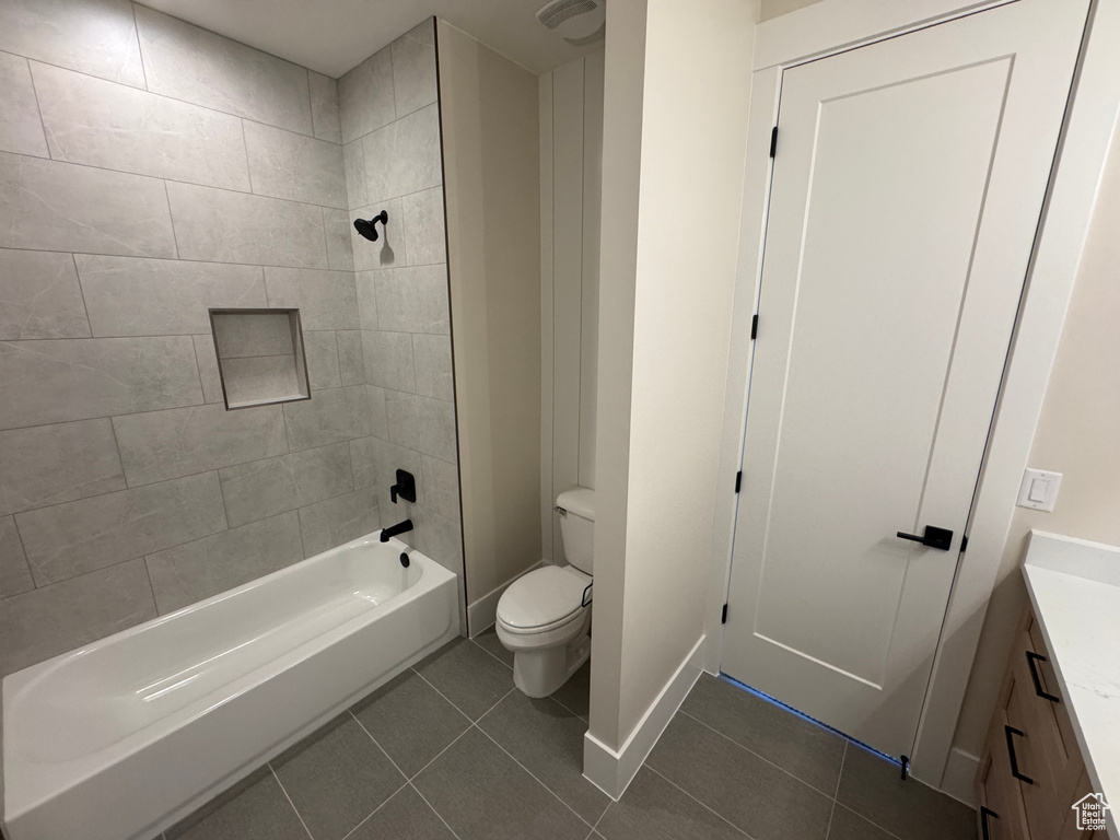 Full bath with tile patterned flooring, toilet,  shower combination, vanity, and baseboards
