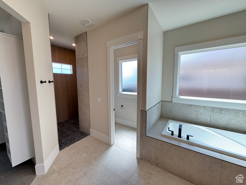 Bathroom with a garden tub, a walk in shower, and baseboards