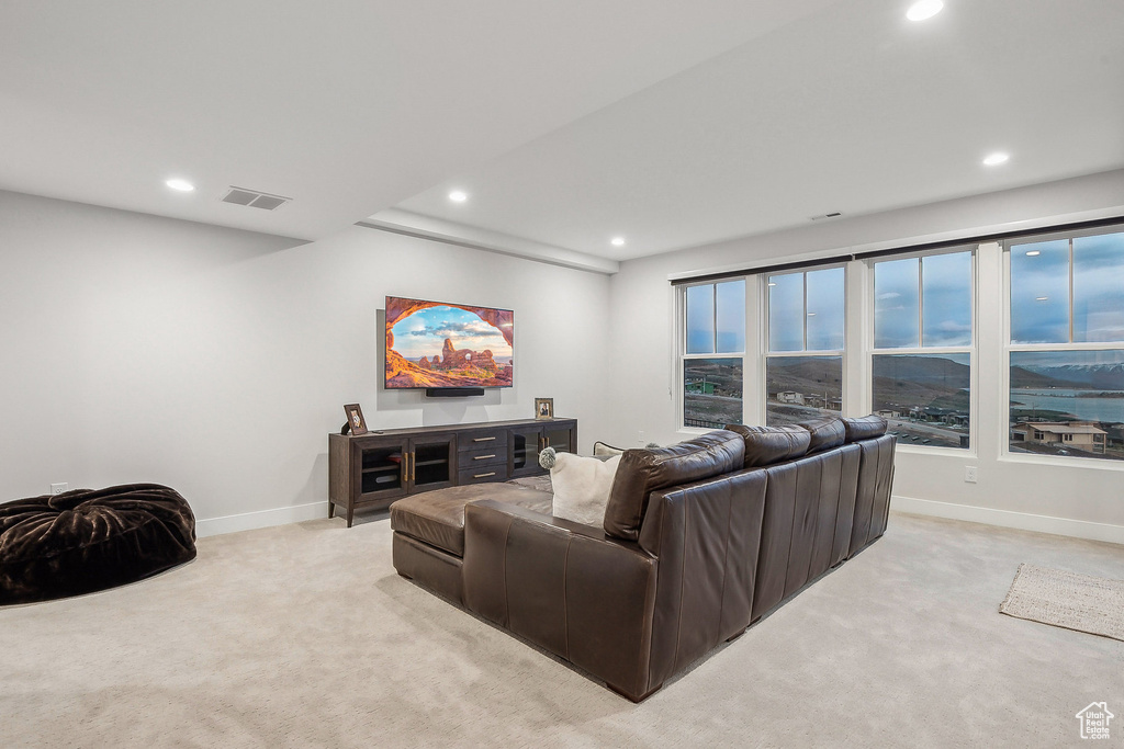 Living room with light colored carpet, recessed lighting, and baseboards