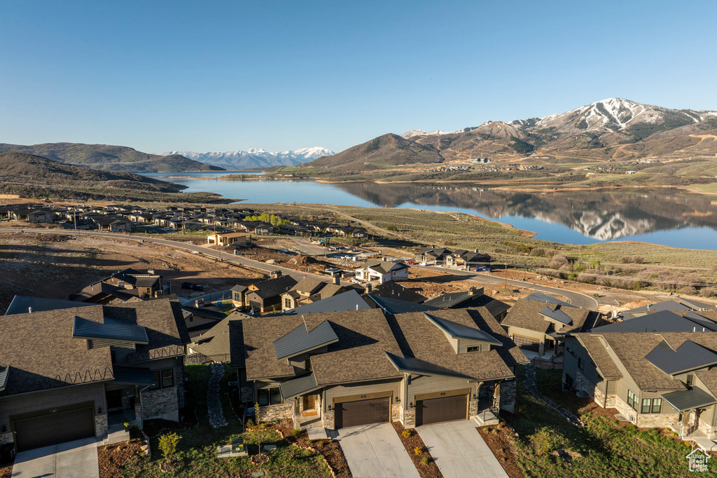 Aerial overview of property's location with a water and mountain view and nearby suburban area
