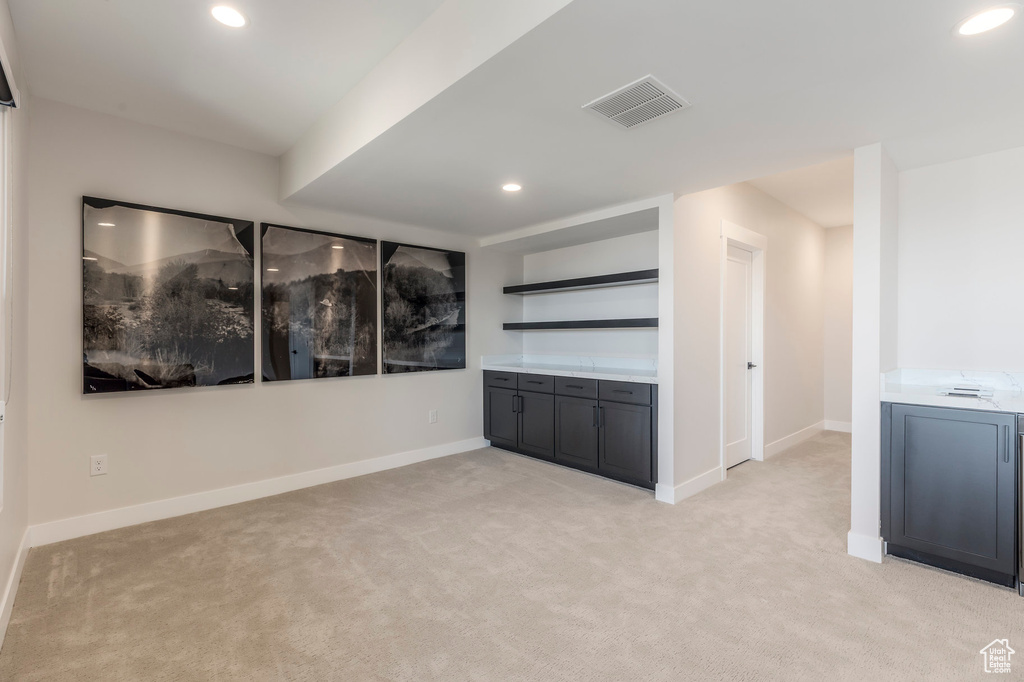 Empty room featuring light carpet, recessed lighting, and baseboards
