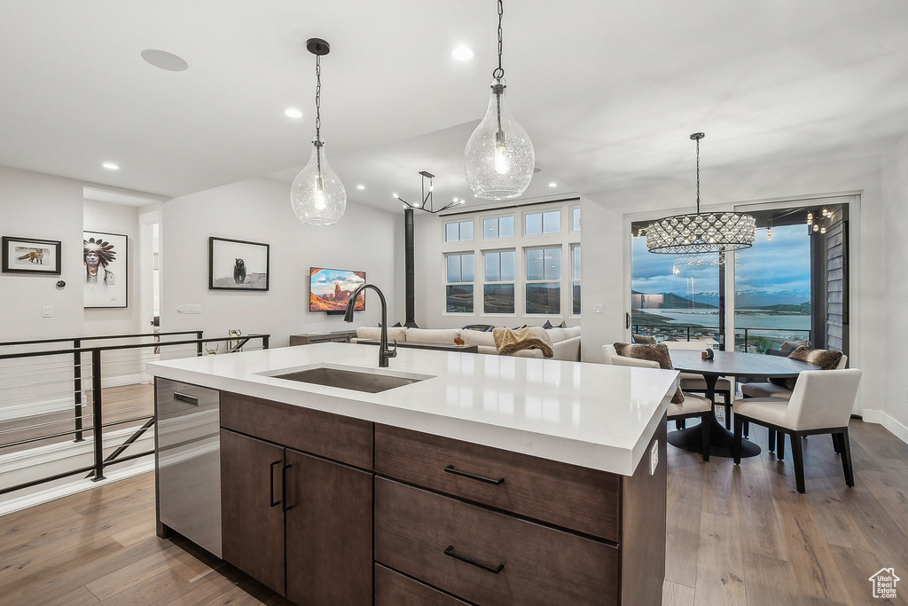Kitchen featuring a sink, a chandelier, recessed lighting, light countertops, and wood finished floors