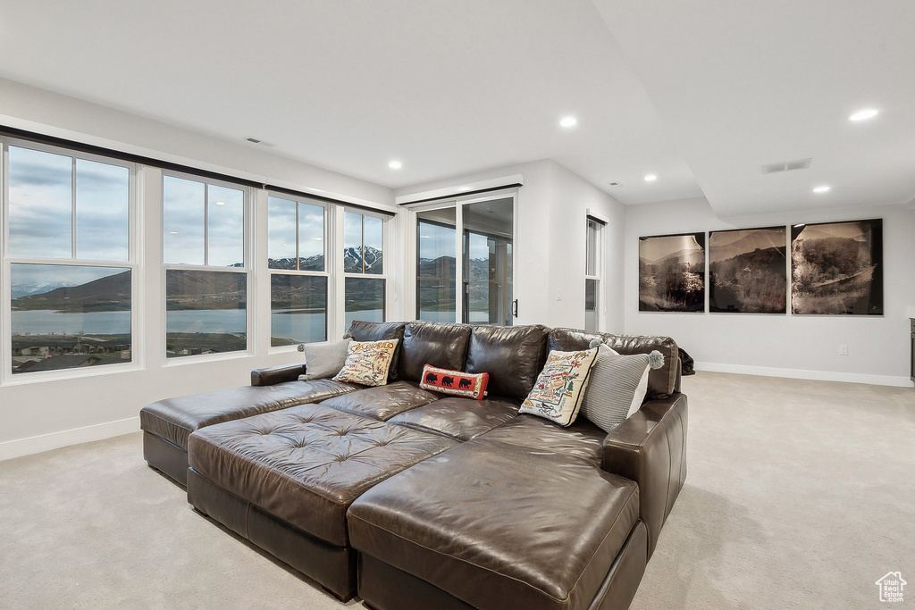 Living area with light carpet, baseboards, and recessed lighting