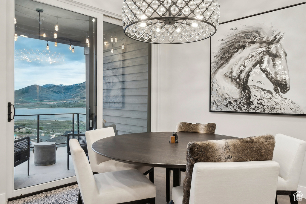 Dining area with a chandelier, a water and mountain view, expansive windows, and rail lighting