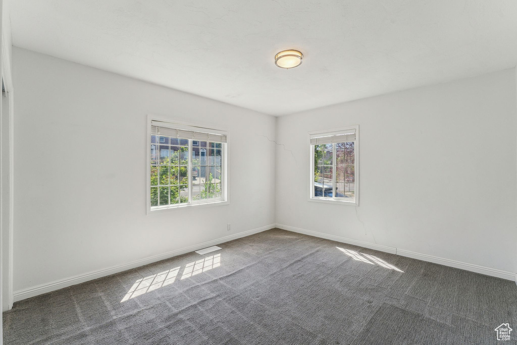 Unfurnished room with visible vents, carpet, baseboards, and a healthy amount of sunlight