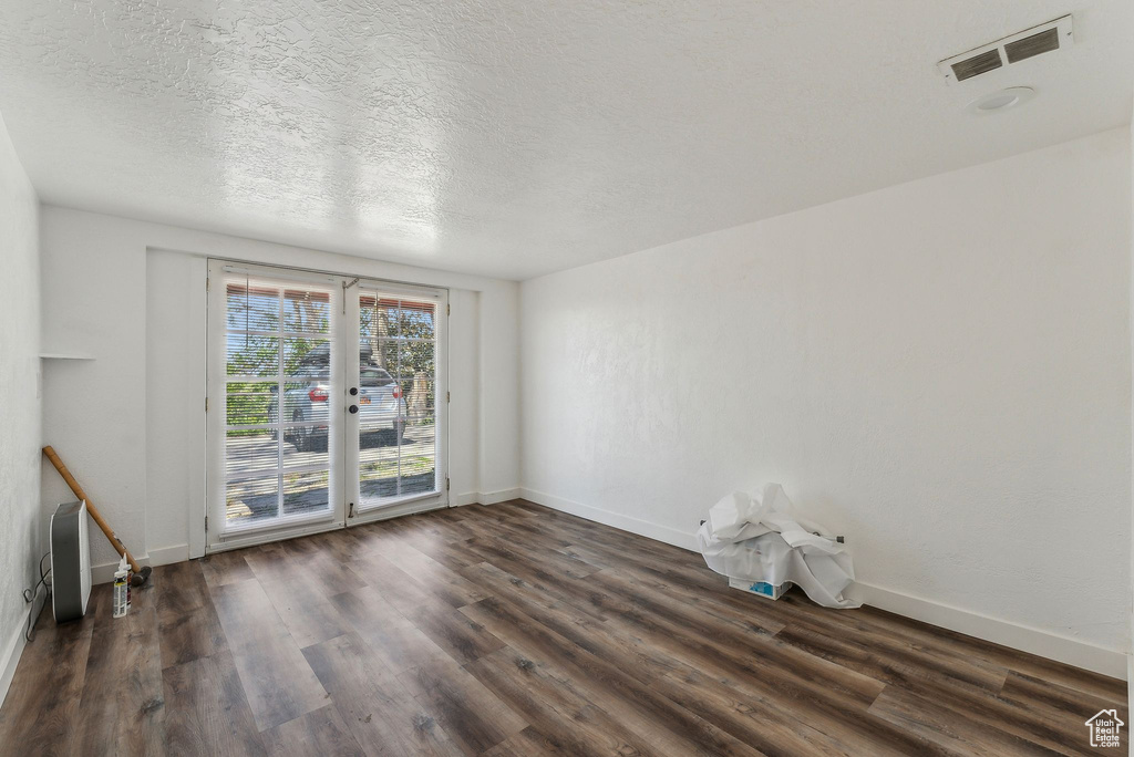 Unfurnished room with baseboards, visible vents, and wood finished floors