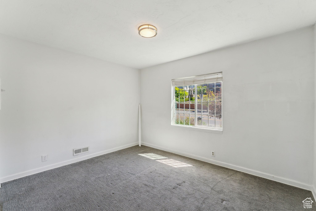 Carpeted spare room with baseboards and visible vents
