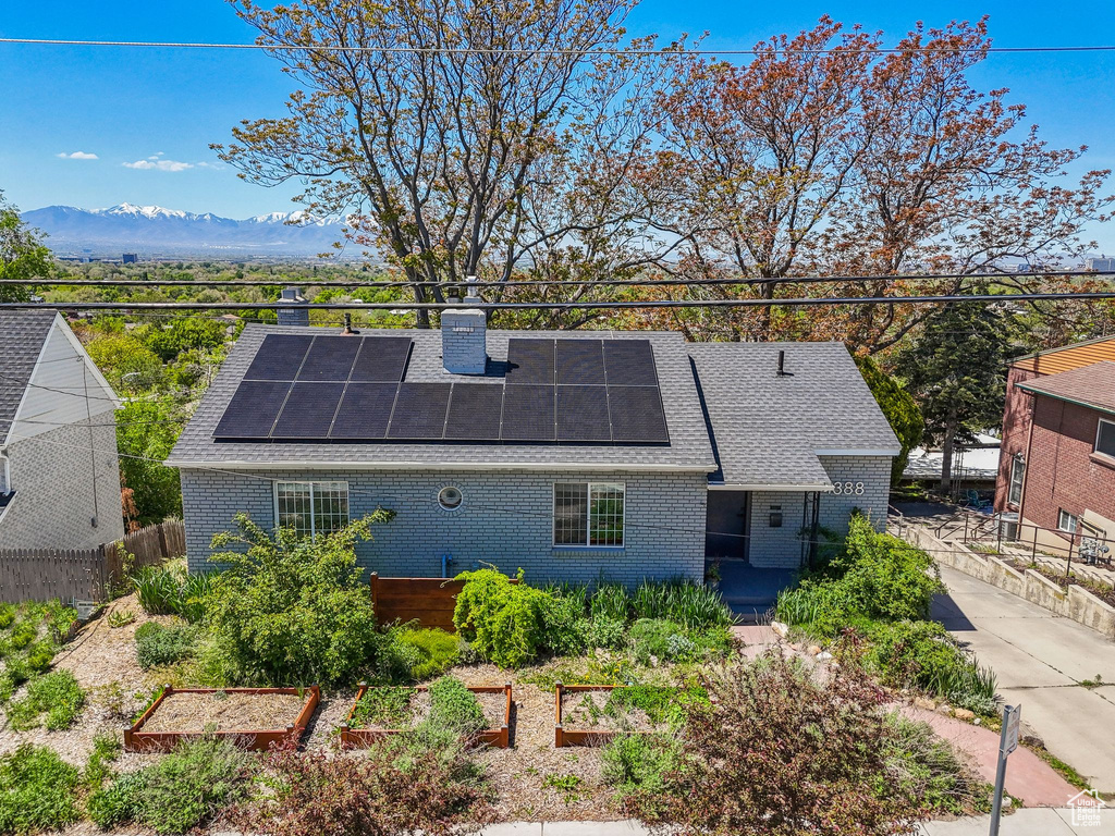 Exterior space with brick siding, solar panels, and a chimney