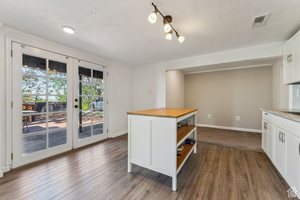 Kitchen with white cabinets, open shelves, dark wood finished floors, and butcher block counters