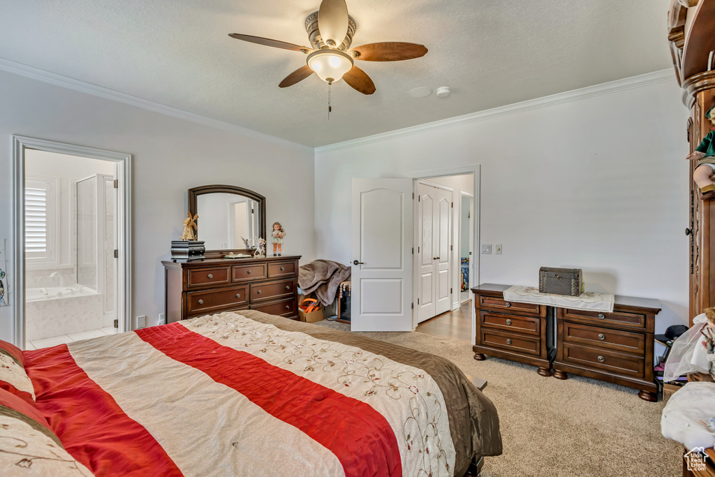 Bedroom with crown molding, carpet floors, connected bathroom, and ceiling fan