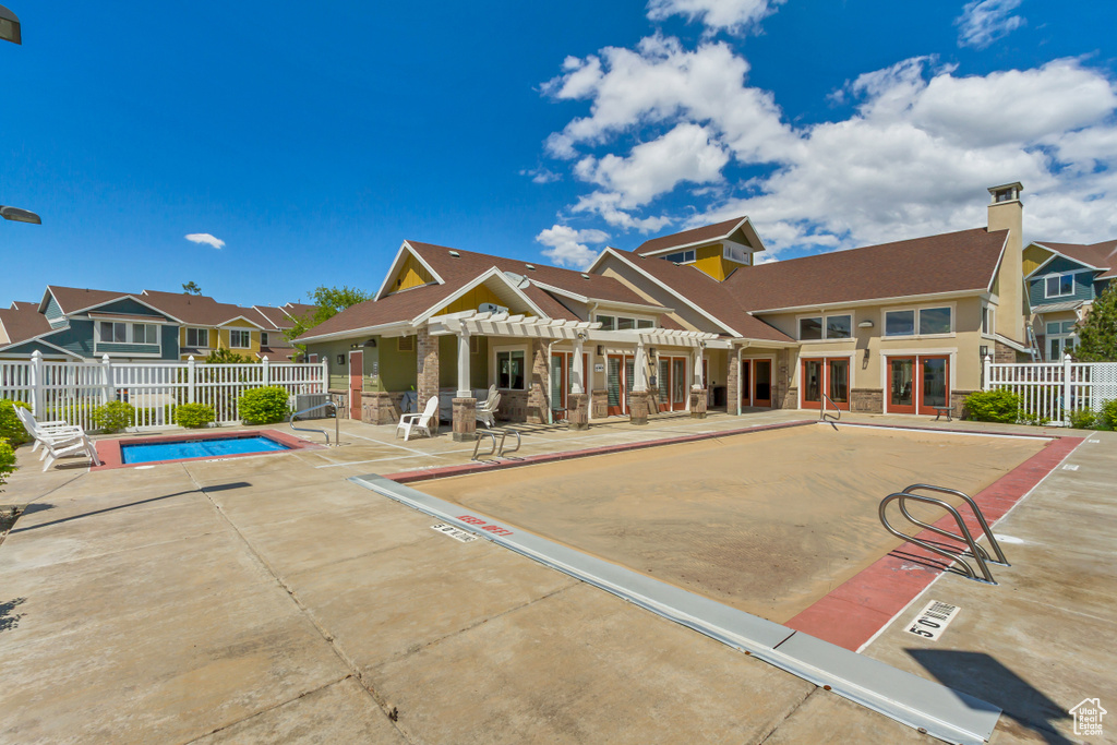 Rear view of property with fence, a pergola, a community pool, a patio, and a residential view