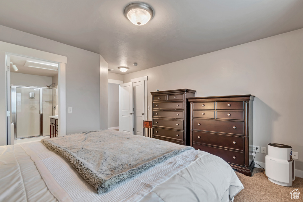 Bedroom featuring baseboards, ensuite bath, and carpet