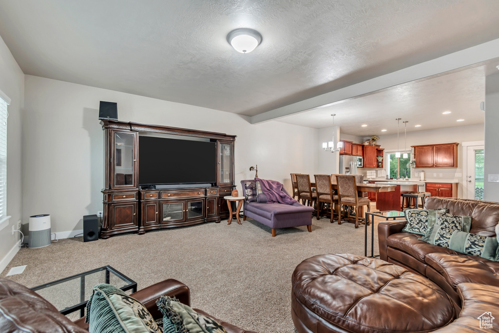 Living room with a textured ceiling, light carpet, baseboards, and recessed lighting