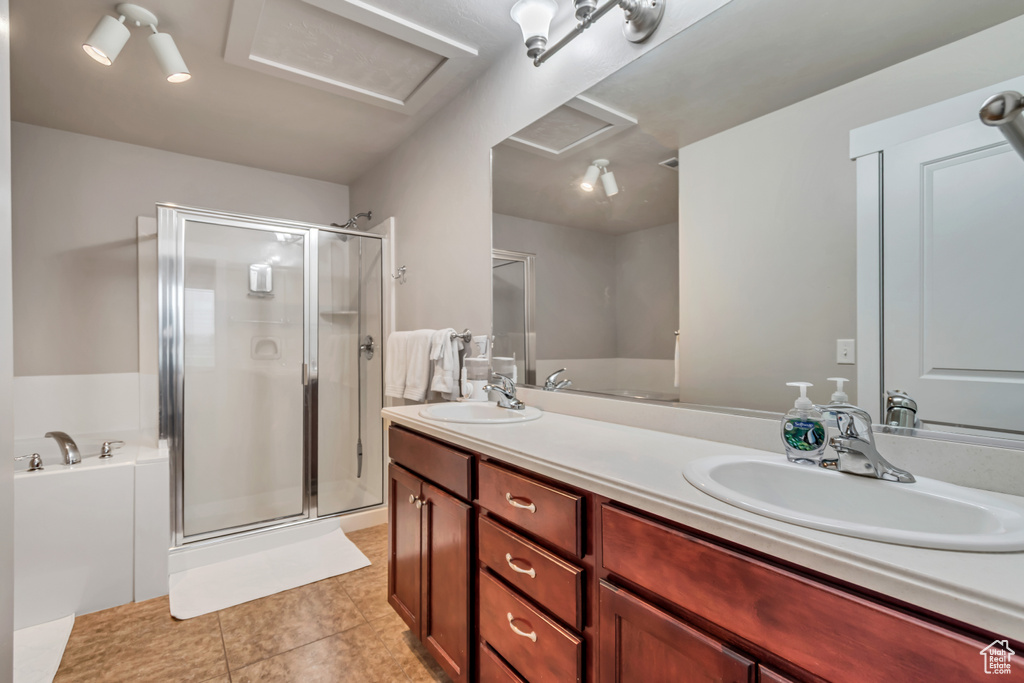 Bathroom with a shower stall, tile patterned floors, double vanity, and a sink