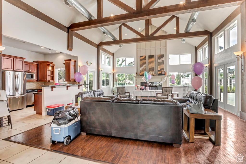 Living area featuring beamed ceiling, high vaulted ceiling, and light wood finished floors