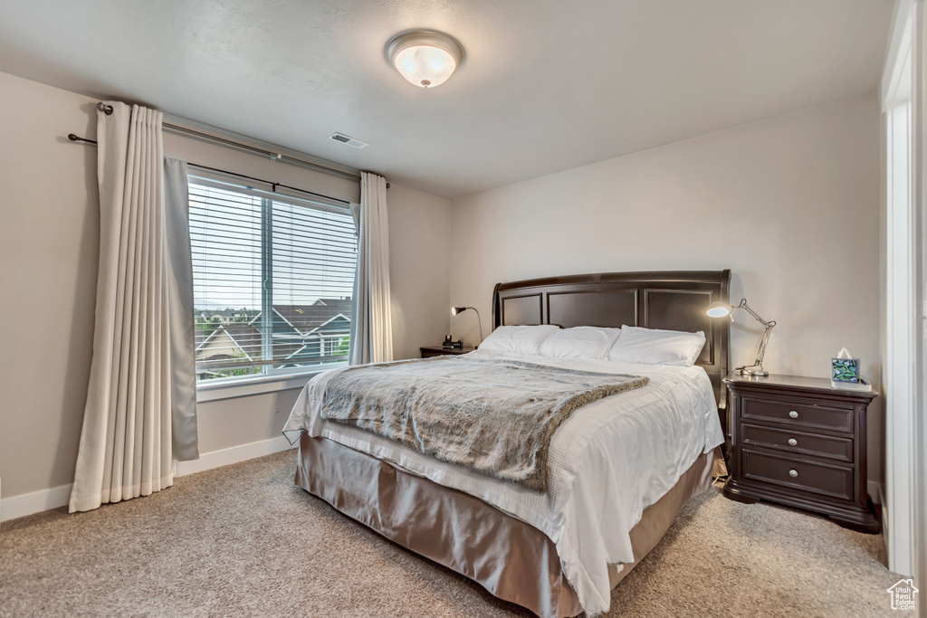 Carpeted bedroom with visible vents and baseboards