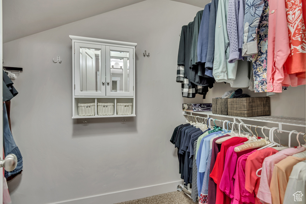 Spacious closet with vaulted ceiling and carpet floors