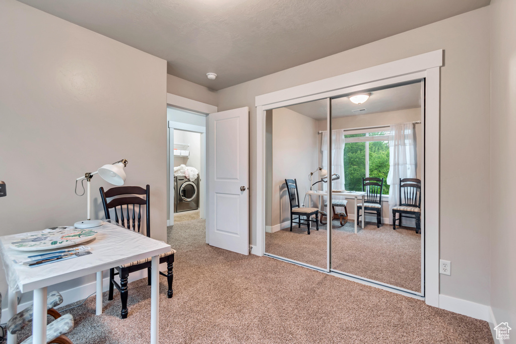Carpeted office space featuring baseboards and washer / clothes dryer